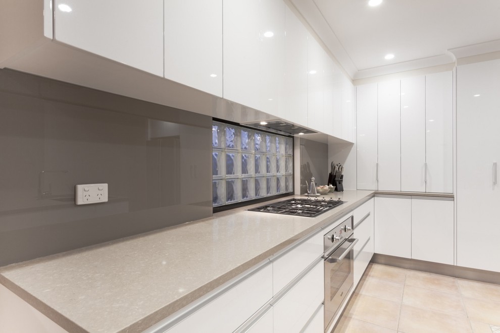 Large l-shaped separate kitchen in Other with a single-bowl sink, flat-panel cabinets, white cabinets, quartz benchtops, white splashback, subway tile splashback, white appliances, travertine floors and with island.