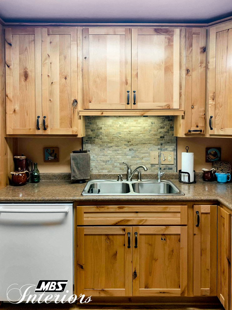 Mid-sized mountain style l-shaped light wood floor and beige floor eat-in kitchen photo with a drop-in sink, shaker cabinets, light wood cabinets, laminate countertops, multicolored backsplash, stone tile backsplash, white appliances, no island and brown countertops