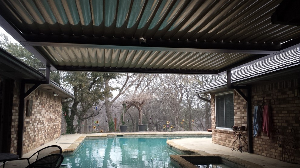 Example of a mid-sized mountain style backyard concrete patio design in Dallas with a pergola
