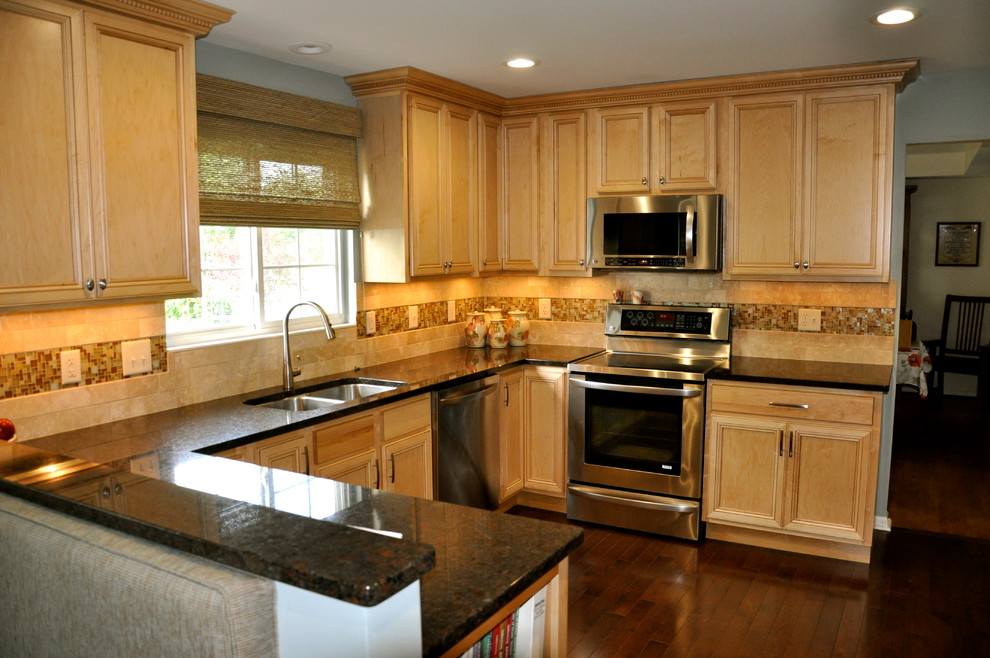 Mid-sized transitional u-shaped dark wood floor enclosed kitchen photo in Cincinnati with an undermount sink, shaker cabinets, light wood cabinets, granite countertops, beige backsplash, stainless steel appliances and blue walls