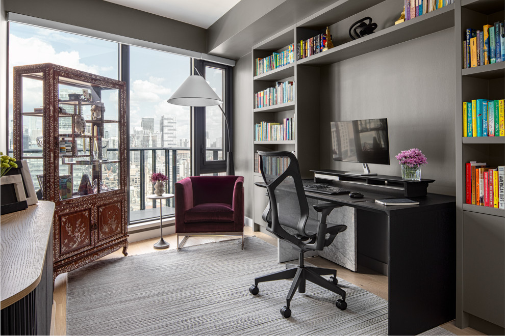 Inspiration for a large contemporary home office in Toronto with a reading nook, grey walls, light hardwood flooring, a freestanding desk and beige floors.