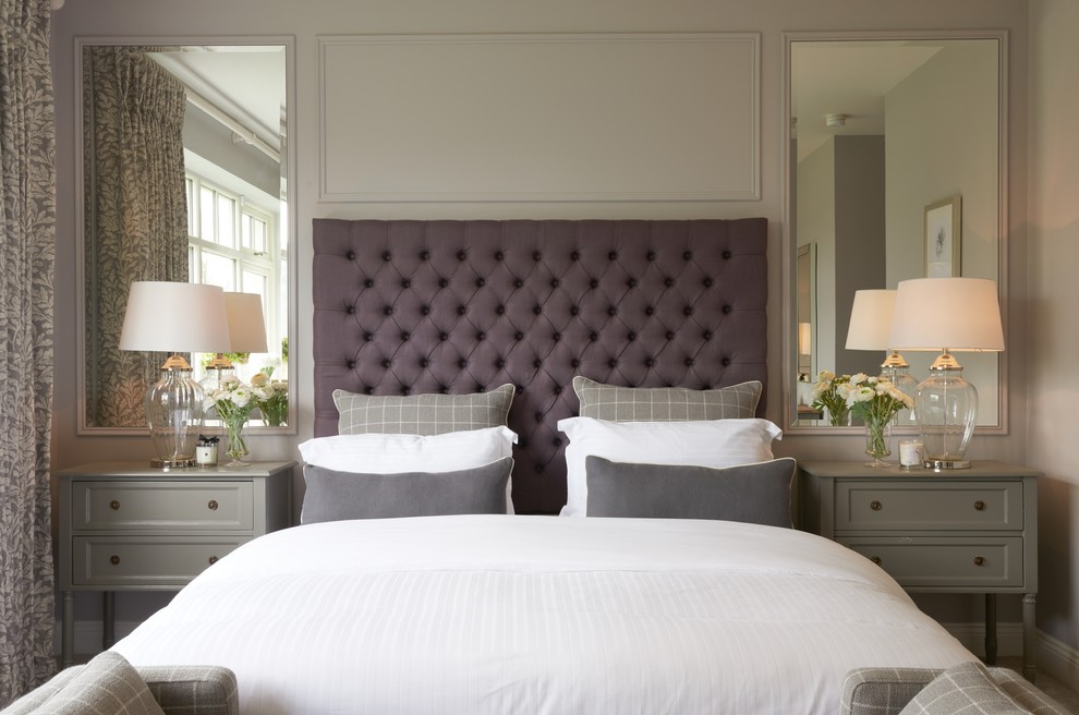 This is an example of a transitional master bedroom in Dublin with grey walls.
