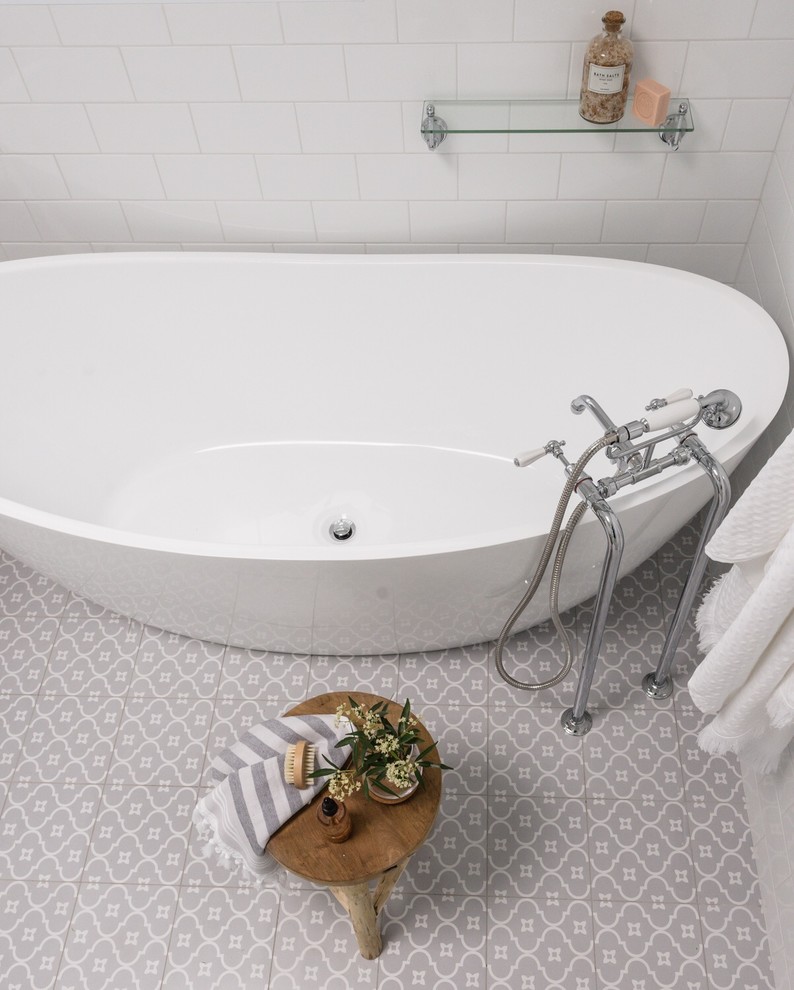 Inspiration for a mid-sized contemporary master bathroom in Sydney with furniture-like cabinets, grey cabinets, a freestanding tub, a corner shower, a one-piece toilet, white tile, subway tile, white walls, porcelain floors, a drop-in sink, marble benchtops, grey floor, a hinged shower door and white benchtops.