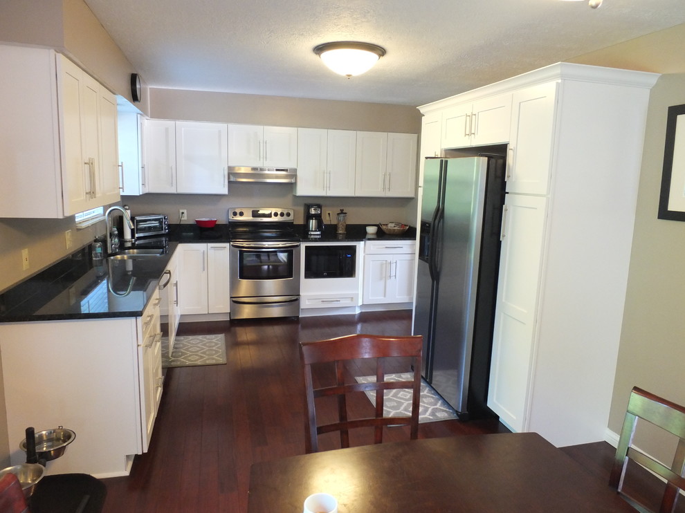 Enclosed kitchen - mid-sized contemporary l-shaped dark wood floor enclosed kitchen idea in Columbus with an undermount sink, shaker cabinets, yellow cabinets, granite countertops, beige backsplash, stainless steel appliances and no island