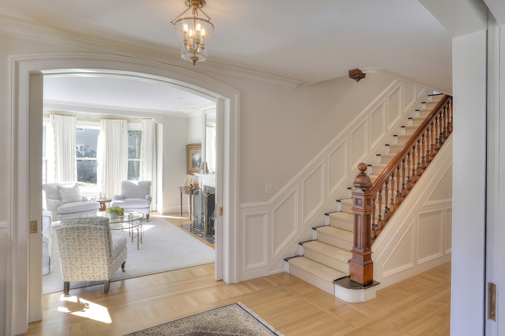 Mittelgroßes Klassisches Foyer mit beiger Wandfarbe, hellem Holzboden, Einzeltür, weißer Haustür, beigem Boden und vertäfelten Wänden in Bridgeport