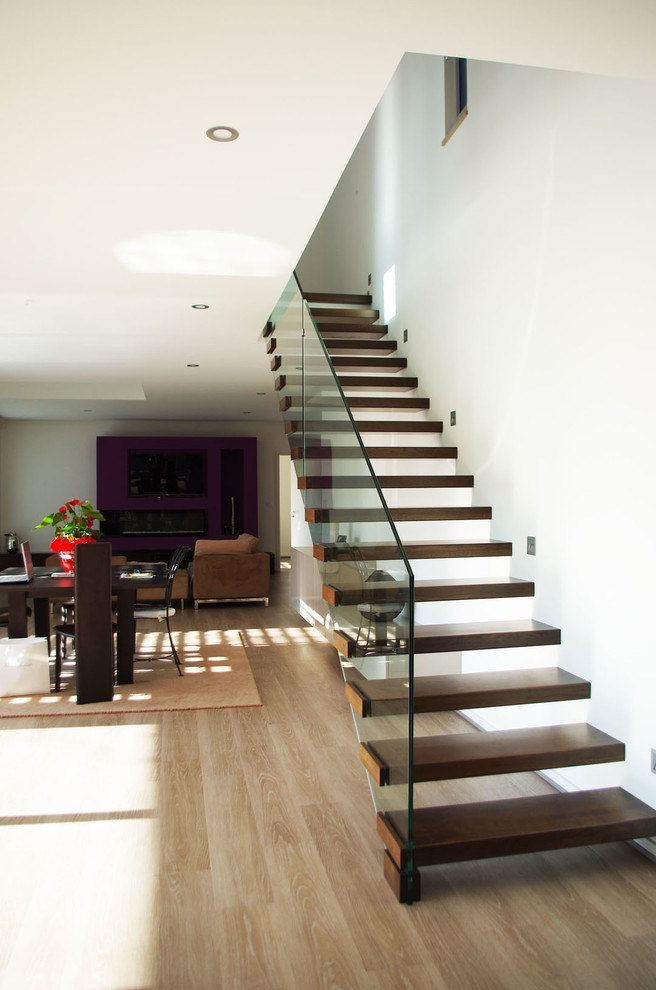 This is an example of a large modern wood floating staircase in Strasbourg with open risers.