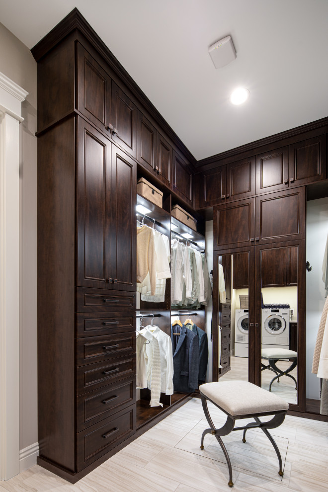 Inspiration for an expansive transitional gender-neutral dressing room in San Francisco with recessed-panel cabinets, dark wood cabinets, ceramic floors and beige floor.