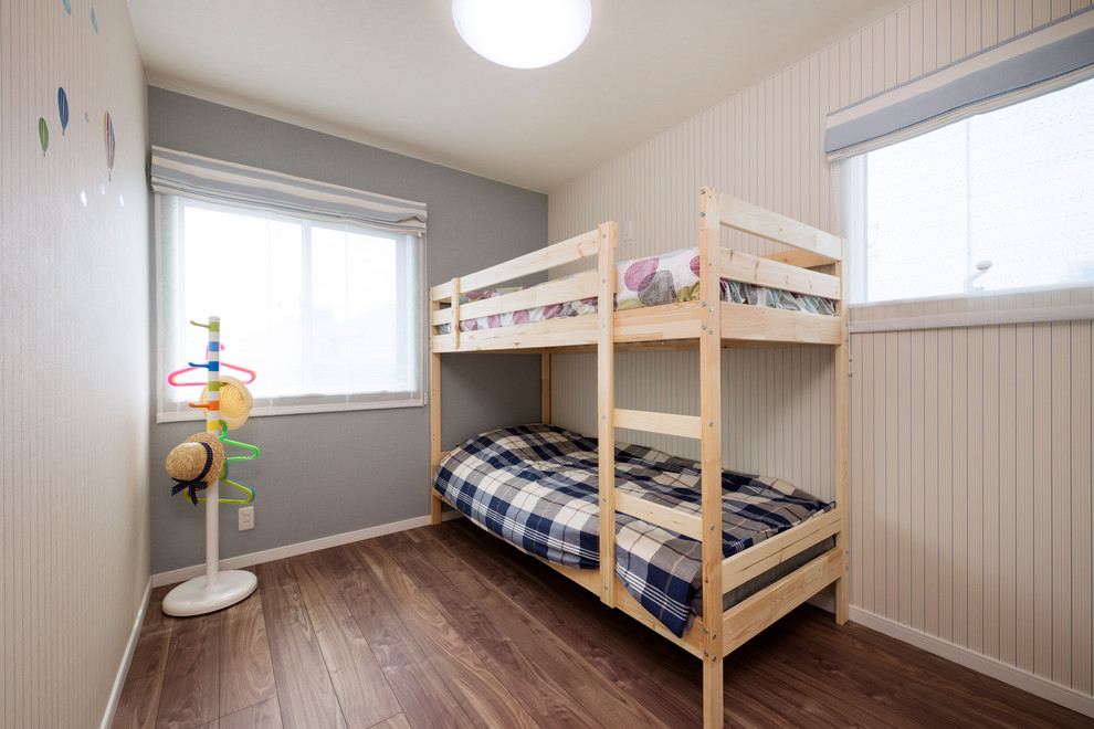 This is an example of a mid-sized country gender-neutral kids' bedroom for kids 4-10 years old in Other with beige walls and brown floor.