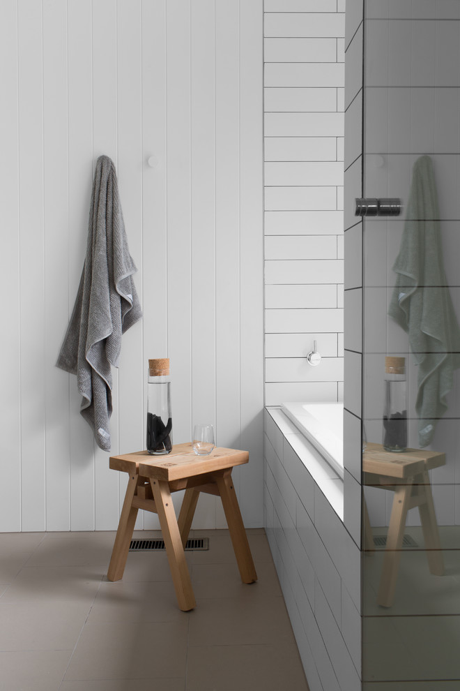 Design ideas for a contemporary bathroom in Melbourne with a drop-in tub, white tile, white walls and beige floor.
