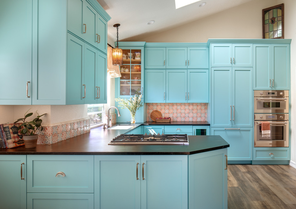Photo of a mid-sized traditional u-shaped eat-in kitchen in San Diego with shaker cabinets, multi-coloured splashback, ceramic splashback, an undermount sink, turquoise cabinets, soapstone benchtops, stainless steel appliances, laminate floors and vaulted.
