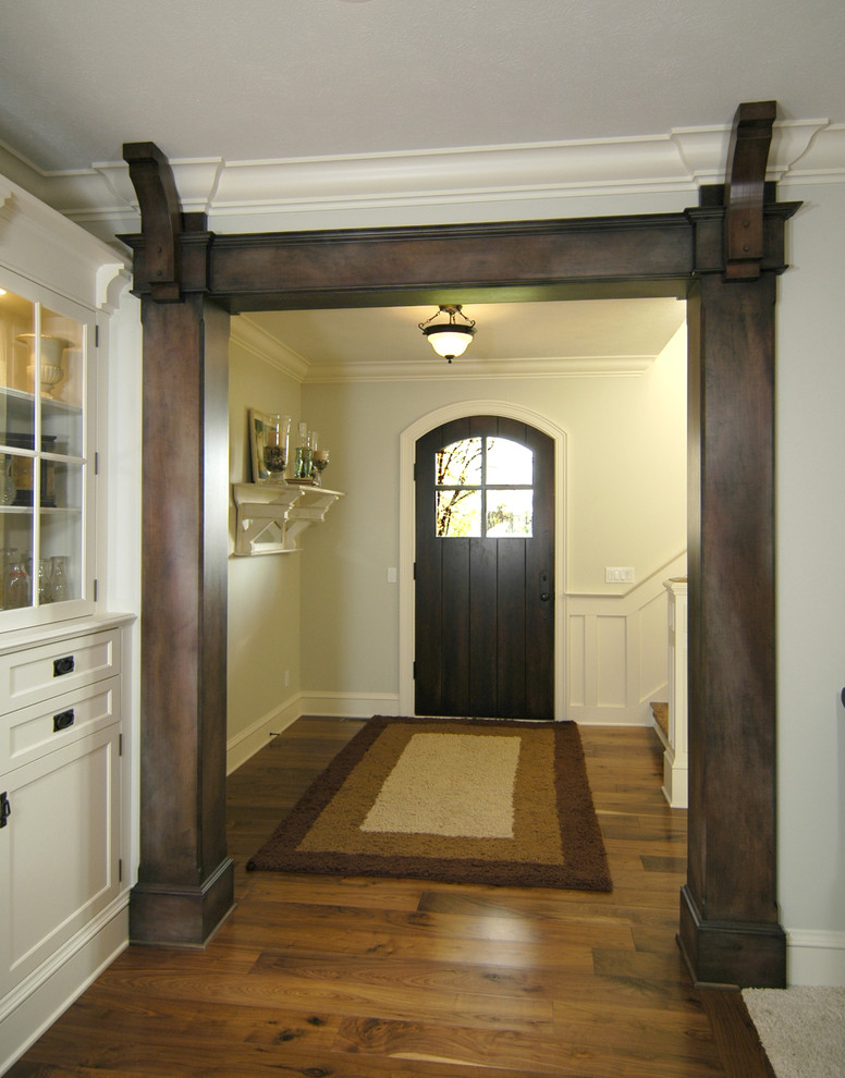 This is an example of a country foyer in Grand Rapids with white walls, cork floors, a single front door, a dark wood front door and brown floor.