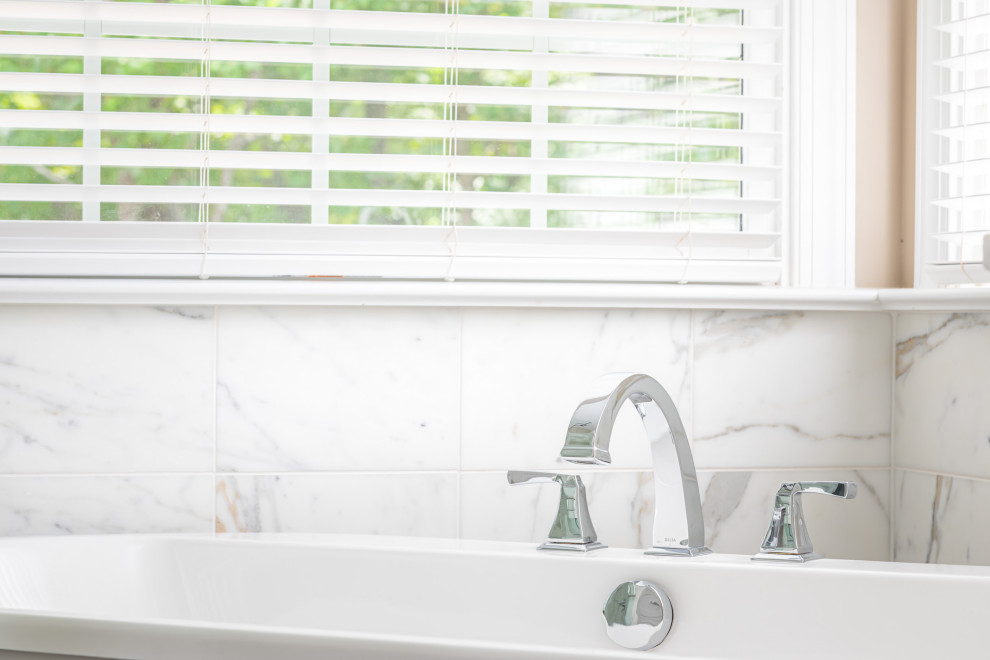 Freestanding bathtub - mid-sized transitional master white tile and marble tile dark wood floor and brown floor freestanding bathtub idea in Raleigh with recessed-panel cabinets, white cabinets, beige walls, an undermount sink, marble countertops, a hinged shower door and white countertops
