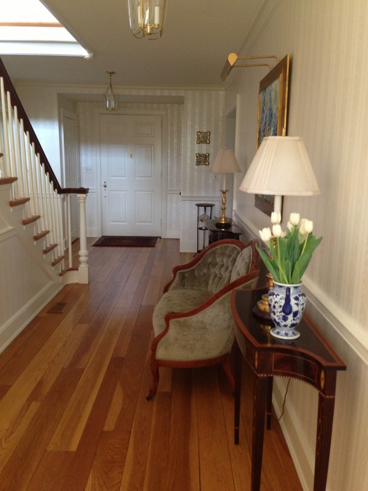 Hallway - medium tone wood floor hallway idea with white walls