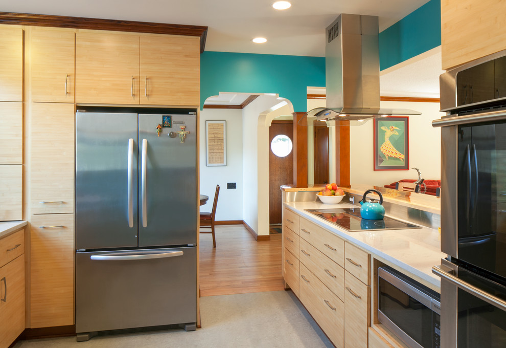 Design ideas for a transitional u-shaped eat-in kitchen in Portland with flat-panel cabinets, light wood cabinets, stainless steel appliances, quartz benchtops, metallic splashback, metal splashback and linoleum floors.
