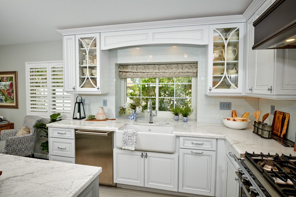 Design ideas for a mid-sized traditional u-shaped eat-in kitchen in Denver with a farmhouse sink, raised-panel cabinets, blue cabinets, marble benchtops, blue splashback, ceramic splashback, black appliances, porcelain floors, with island, grey floor and yellow benchtop.