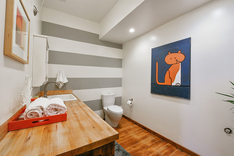 Mid-sized eclectic 3/4 bathroom in San Francisco with a drop-in sink, furniture-like cabinets, grey cabinets, wood benchtops, a two-piece toilet, multi-coloured walls and medium hardwood floors.