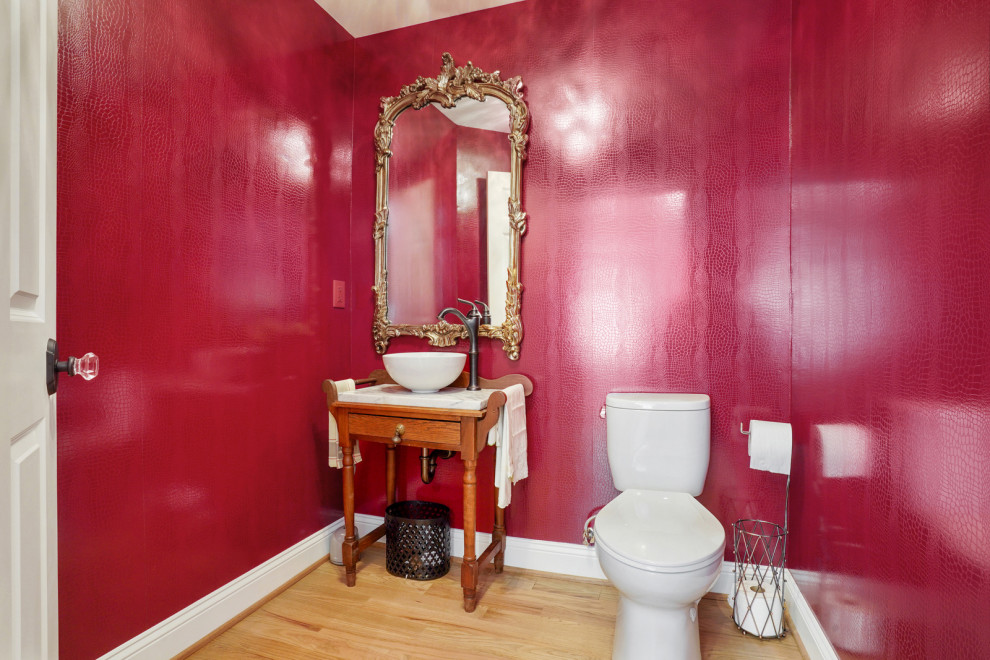 Пример оригинального дизайна: туалет среднего размера в стиле неоклассика (современная классика) с фасадами цвета дерева среднего тона, красными стенами, светлым паркетным полом, мраморной столешницей, белой столешницей, напольной тумбой и обоями на стенах
