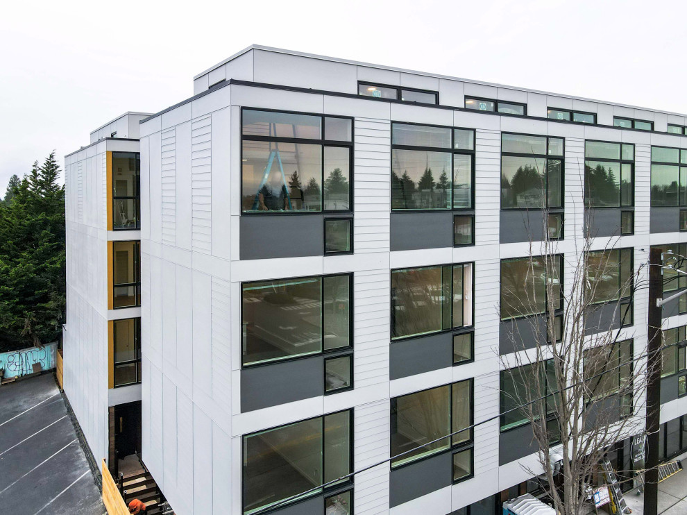 シアトルにある高級なミッドセンチュリースタイルのおしゃれな家の外観 (コンクリート繊維板サイディング、アパート・マンション、混合材屋根、縦張り) の写真