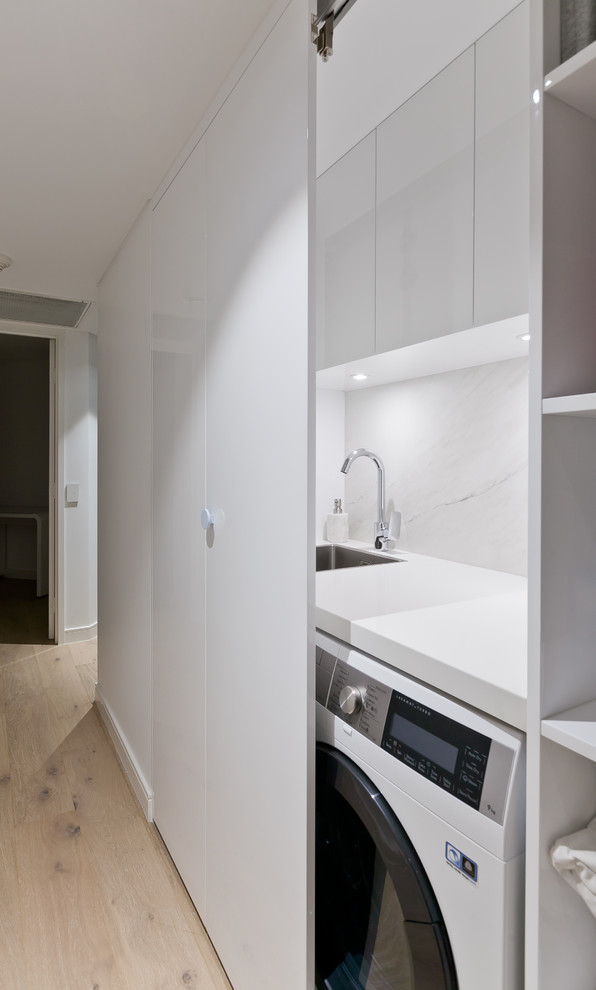 This is an example of a small contemporary single-wall dedicated laundry room in Perth with an undermount sink, flat-panel cabinets, white cabinets, quartz benchtops, white walls and white benchtop.
