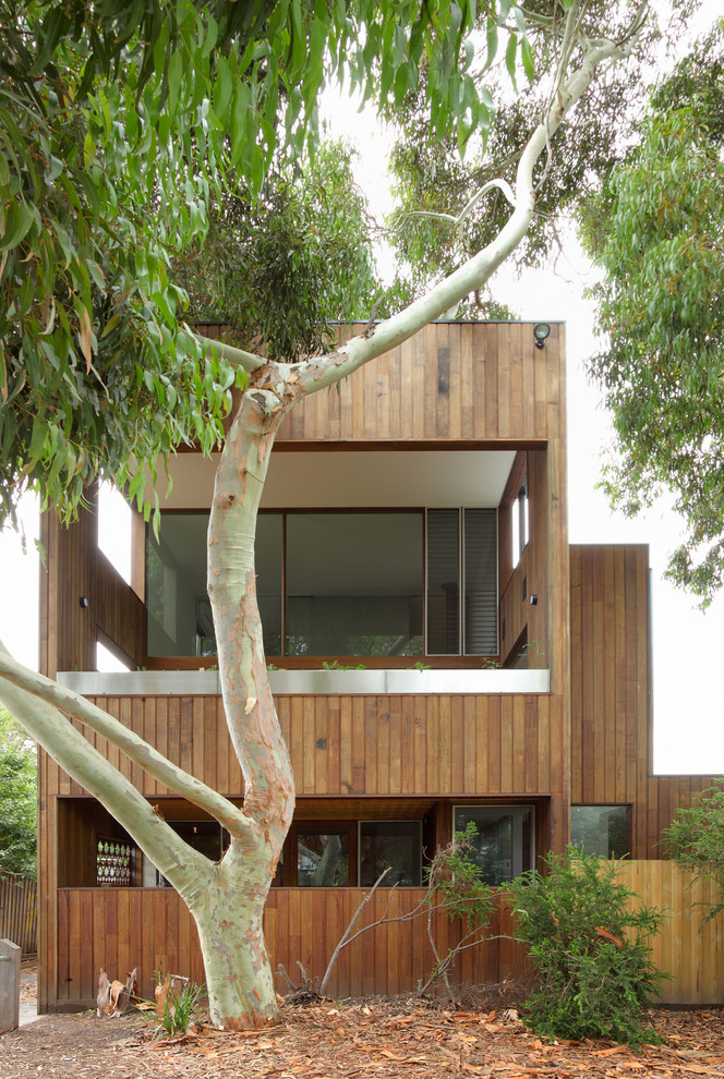 Photo of a large two-storey beige exterior in Melbourne with wood siding and a flat roof.