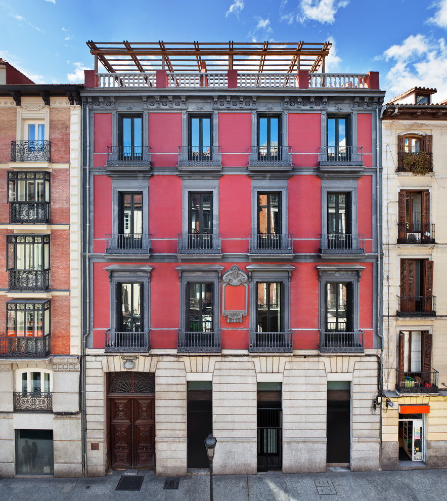 Inspiration for a traditional three-storey red apartment exterior in Other with a flat roof.