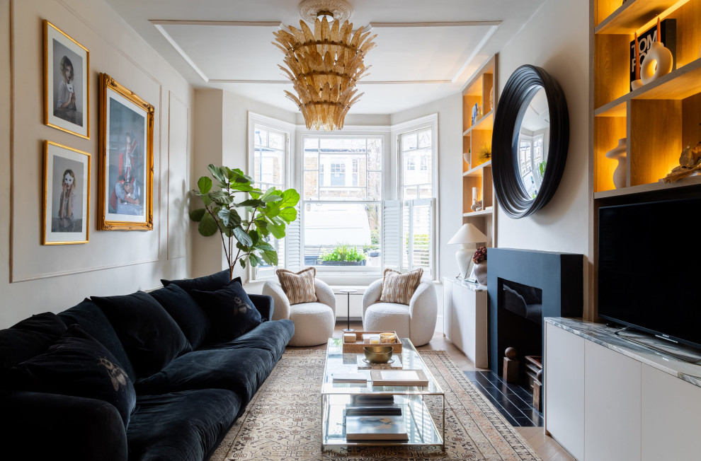 Inspiration for a traditional living room in London with beige walls, medium hardwood flooring, a standard fireplace, a freestanding tv and brown floors.