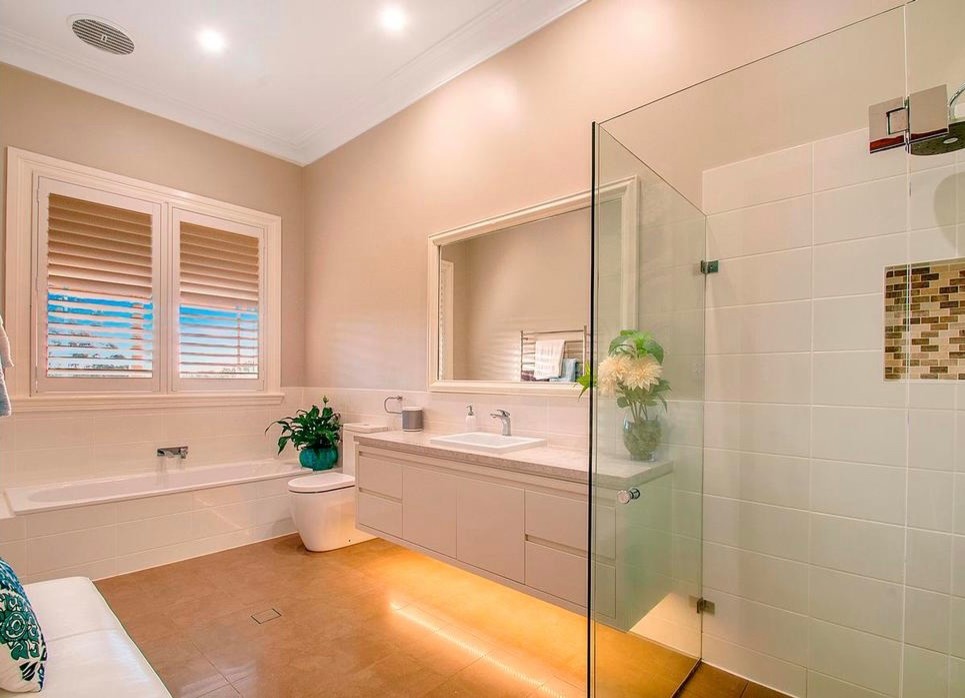 Design ideas for a large modern kids bathroom in Sydney with flat-panel cabinets, white cabinets, a drop-in tub, an open shower, a one-piece toilet, white tile, ceramic tile, beige walls, ceramic floors, an integrated sink and engineered quartz benchtops.