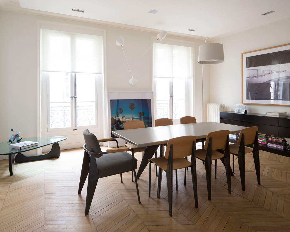 This is an example of a large contemporary dining room in Lyon with white walls and medium hardwood floors.