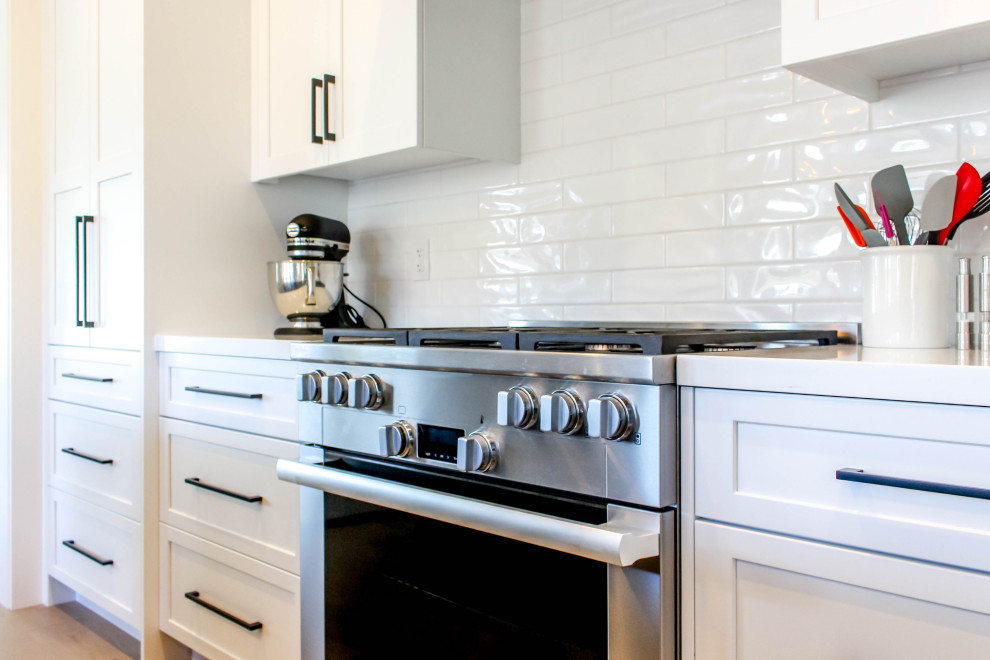 Inspiration for a transitional beige floor kitchen remodel with white backsplash, subway tile backsplash, white countertops, shaker cabinets and quartz countertops