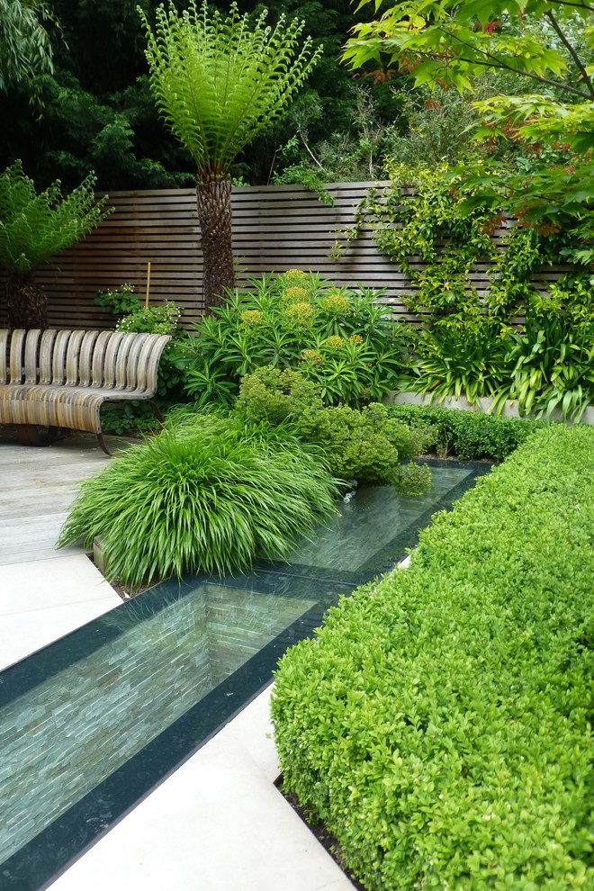 This is an example of a mid-sized contemporary backyard partial sun garden for summer in London.