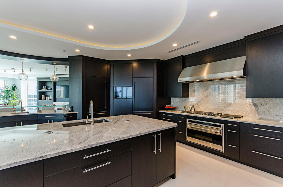 Large modern u-shaped kitchen in Miami with an undermount sink, flat-panel cabinets, dark wood cabinets, granite benchtops, stainless steel appliances and with island.