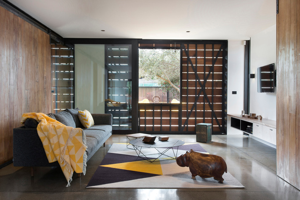 Inspiration for a contemporary open concept living room in Melbourne with white walls, concrete floors and a wall-mounted tv.