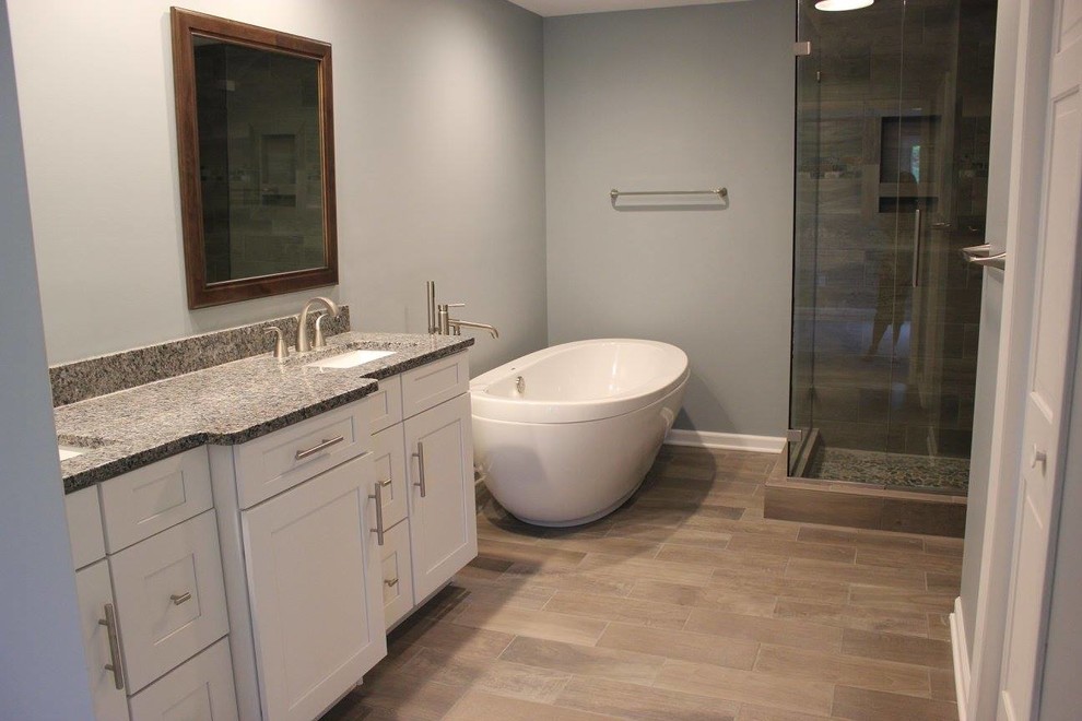 Design ideas for a large transitional master bathroom in Other with shaker cabinets, white cabinets, a freestanding tub, an alcove shower, a two-piece toilet, beige tile, black tile, gray tile, porcelain tile, grey walls, porcelain floors, an undermount sink, granite benchtops, brown floor and a hinged shower door.