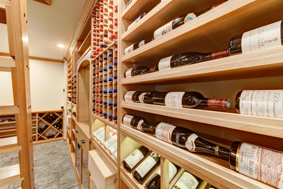 Mid-sized transitional wine cellar in Raleigh with concrete floors, display racks and grey floor.