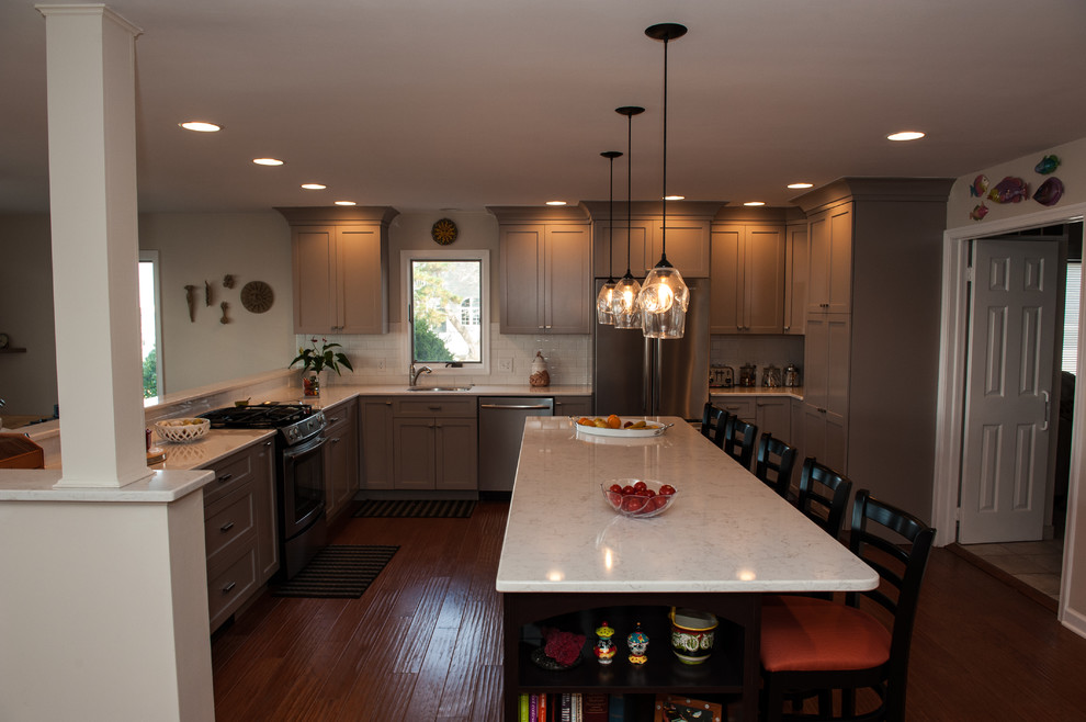 Eat-in kitchen - large transitional l-shaped dark wood floor and brown floor eat-in kitchen idea in Philadelphia with an undermount sink, shaker cabinets, quartz countertops, white backsplash, stainless steel appliances, white cabinets, subway tile backsplash and a peninsula
