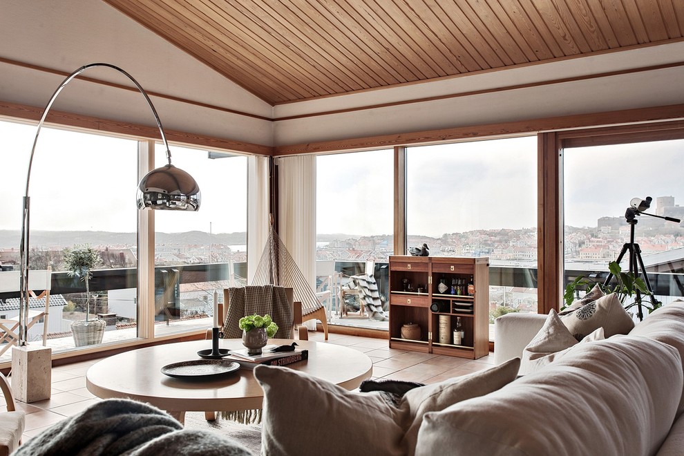 Mid-sized scandinavian open concept living room in Gothenburg with white walls, terra-cotta floors and beige floor.