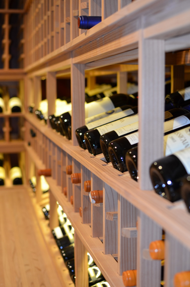 Photo of a large arts and crafts wine cellar in New York with storage racks and grey floor.