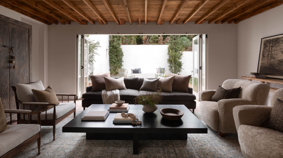 Imagen de salón actual con paredes blancas, suelo de madera en tonos medios, suelo marrón y vigas vistas