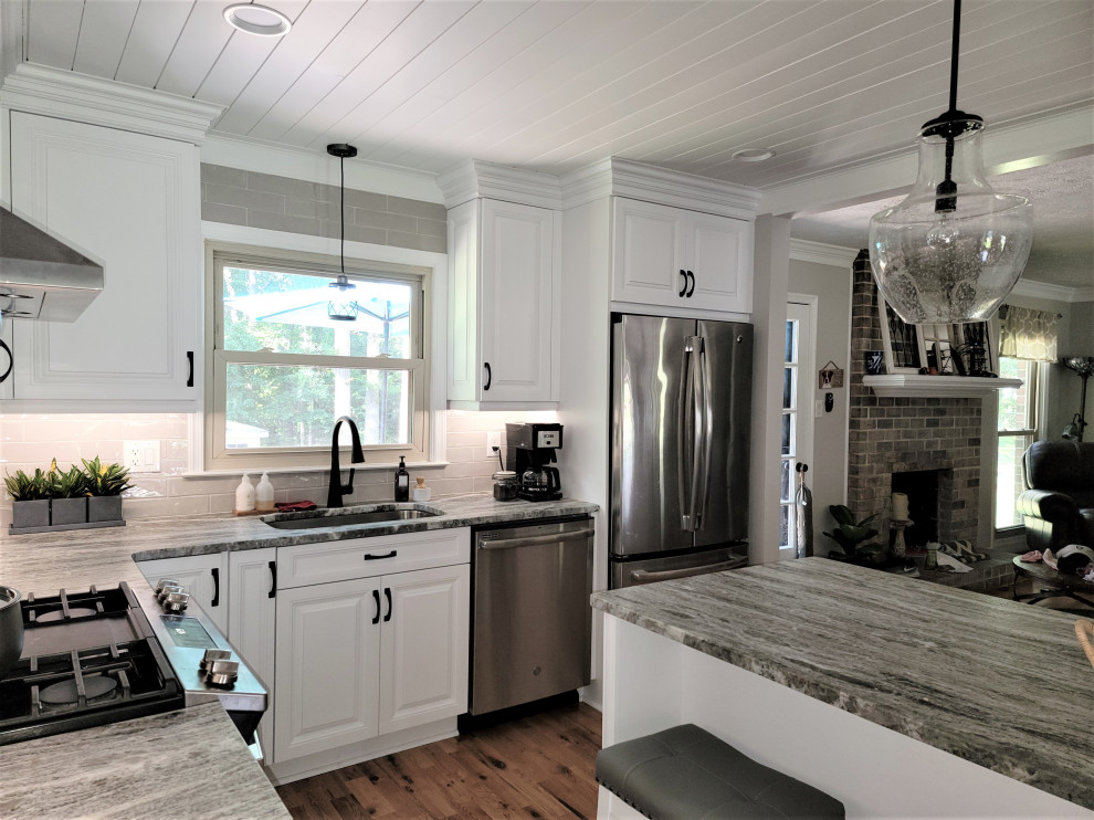 Idéer för stora rustika grått kök, med en undermonterad diskho, luckor med upphöjd panel, vita skåp, bänkskiva i kvartsit, beige stänkskydd, stänkskydd i porslinskakel, rostfria vitvaror, mellanmörkt trägolv, en köksö och brunt golv