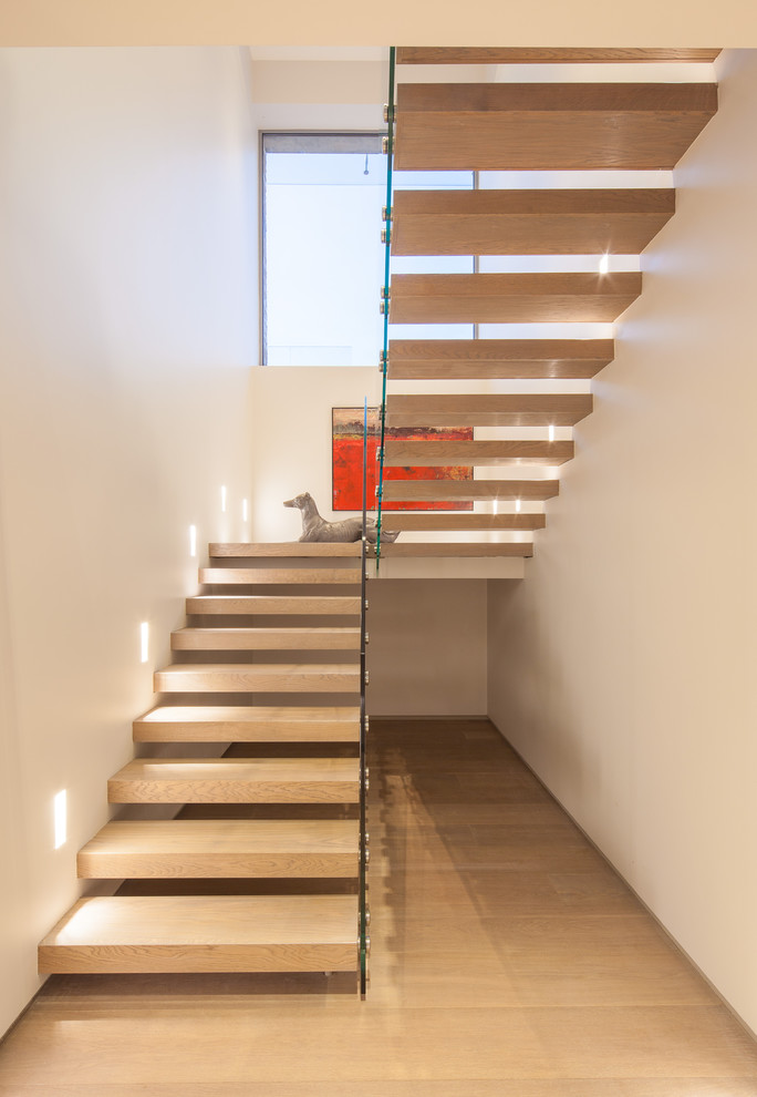 Photo of a contemporary wood floating staircase in Dorset with open risers.