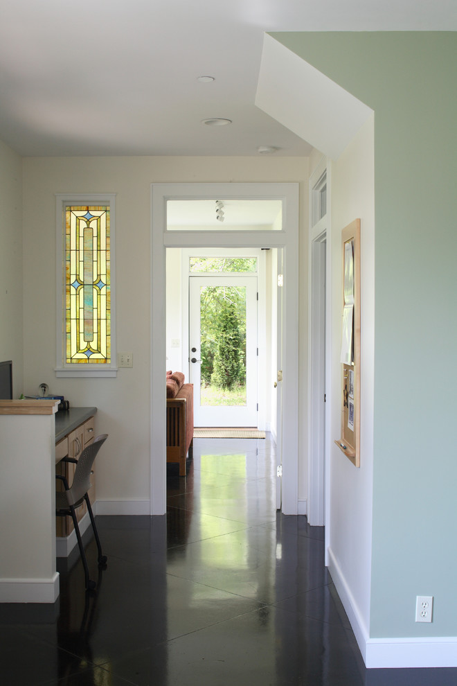 This is an example of a traditional hallway in Portland Maine with beige walls and black floor.