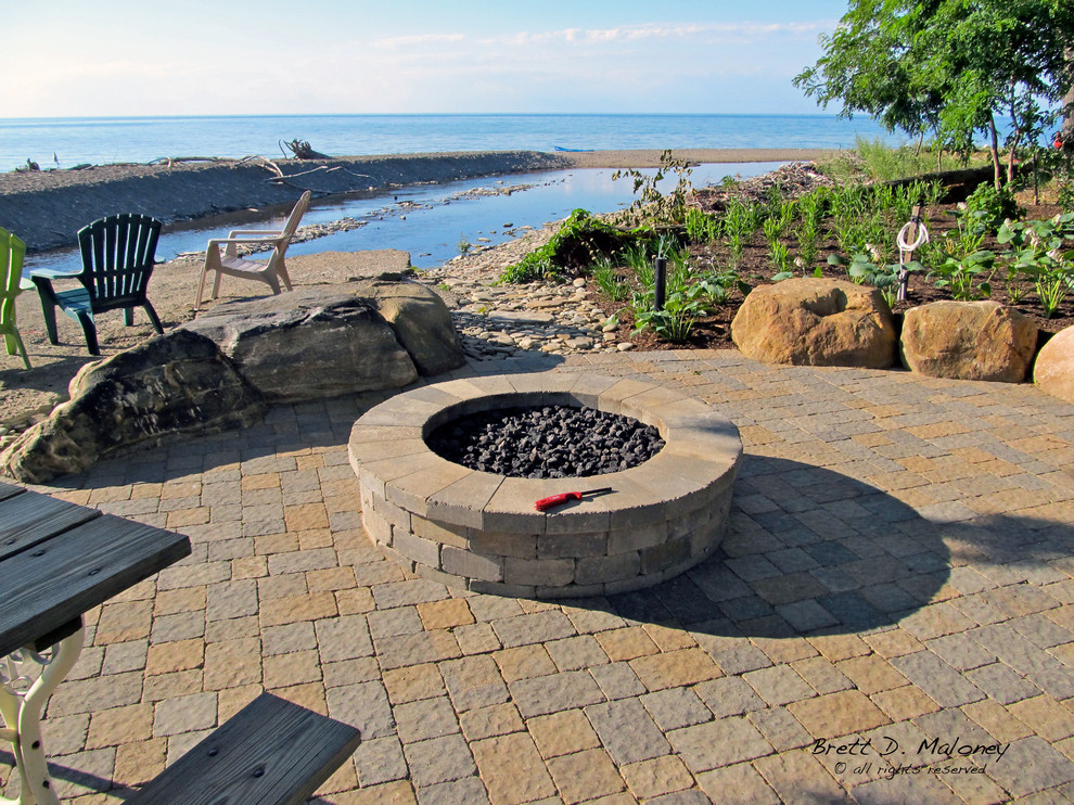 Design ideas for a mid-sized beach style backyard patio in Other with a fire feature and concrete pavers.