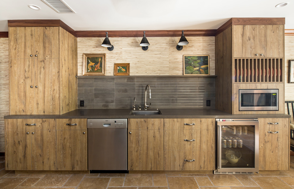 Photo of a transitional single-wall kitchen in Los Angeles with an undermount sink, flat-panel cabinets, medium wood cabinets, stainless steel appliances and grey splashback.