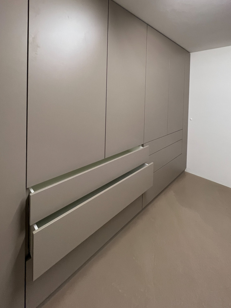 Mid-sized modern u-shaped dedicated laundry room in Cologne with a single-bowl sink, flat-panel cabinets, grey cabinets, wood benchtops, white walls, concrete floors, a side-by-side washer and dryer, beige floor and grey benchtop.