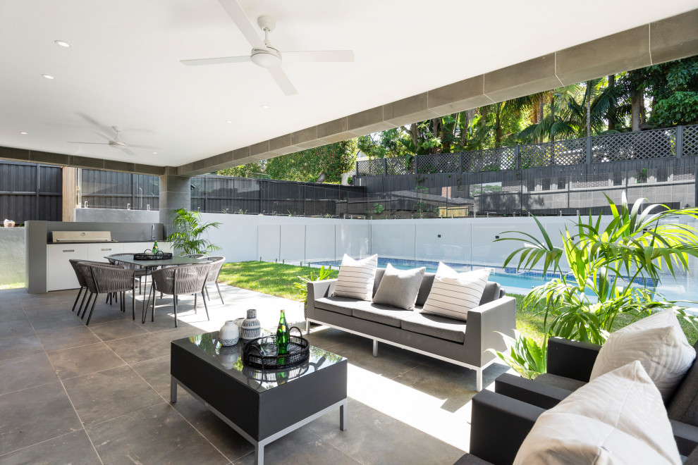 Inspiration for a large contemporary backyard verandah in Sydney with an outdoor kitchen, concrete pavers and a roof extension.