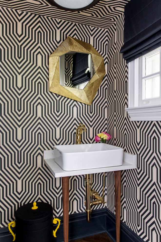 Design ideas for a mid-sized transitional powder room in New York with multi-coloured walls, white benchtops, open cabinets, dark hardwood floors, a console sink, marble benchtops and brown floor.