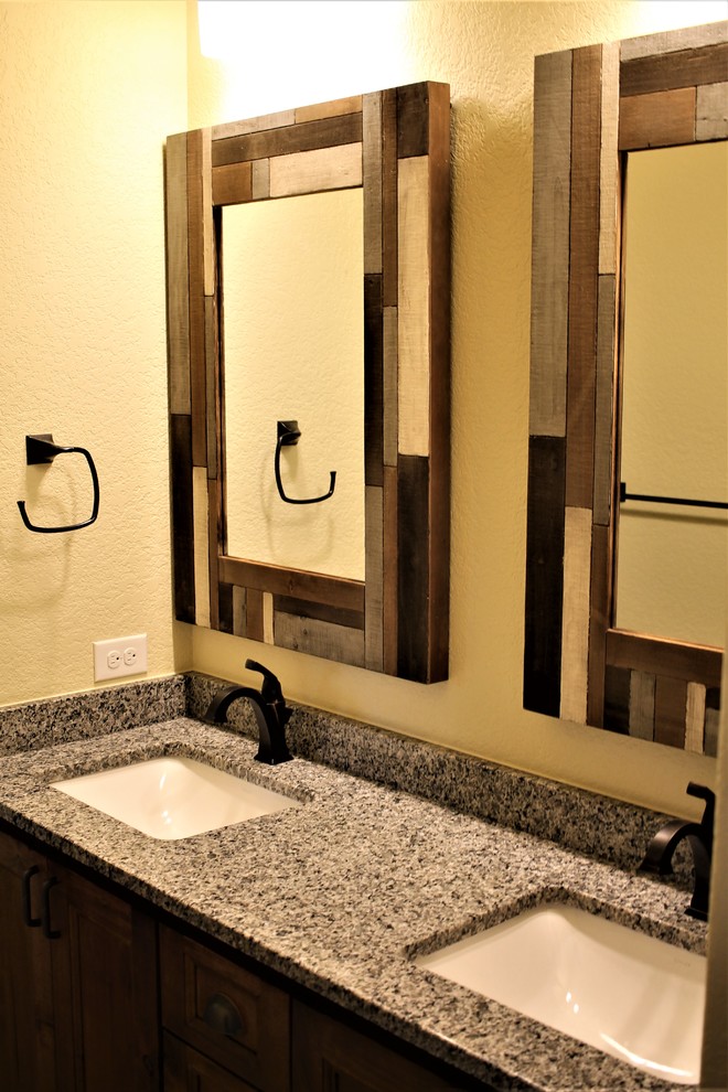 Example of a mid-sized mountain style kids' bathroom design with raised-panel cabinets, dark wood cabinets, beige walls, an undermount sink, granite countertops and multicolored countertops