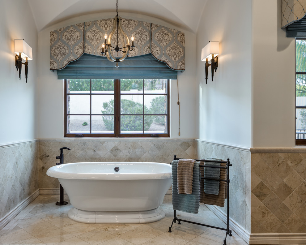 Design ideas for a large traditional master bathroom in Phoenix with a drop-in sink, beaded inset cabinets, dark wood cabinets, granite benchtops, a freestanding tub, an alcove shower, a one-piece toilet, porcelain tile, grey walls and travertine floors.
