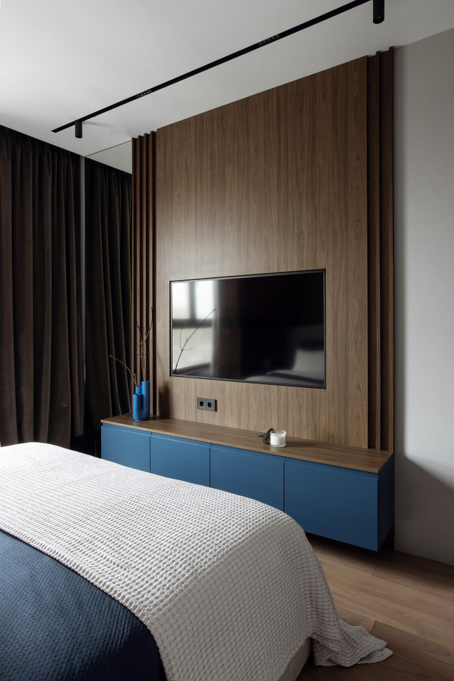 Пример оригинального дизайна: хозяйская спальня среднего размера в современном стиле с серыми стенами, бежевым полом и телевизором