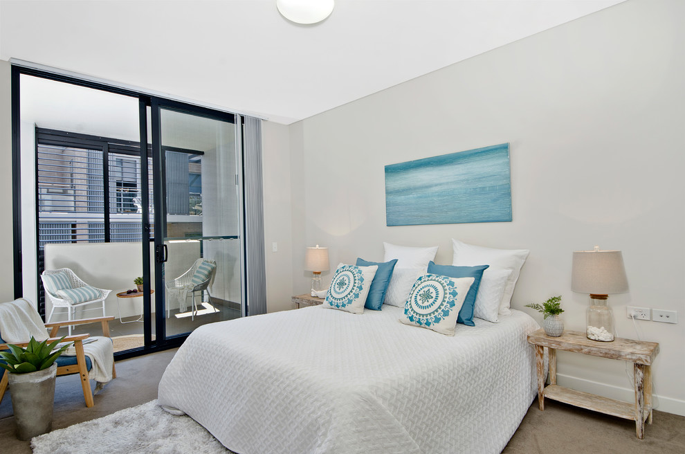 Design ideas for a beach style master bedroom in Sydney with grey walls, carpet and brown floor.